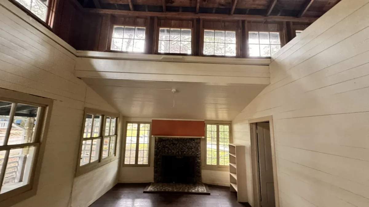 a room with a fireplace and windows Daisy Town at Elkmont