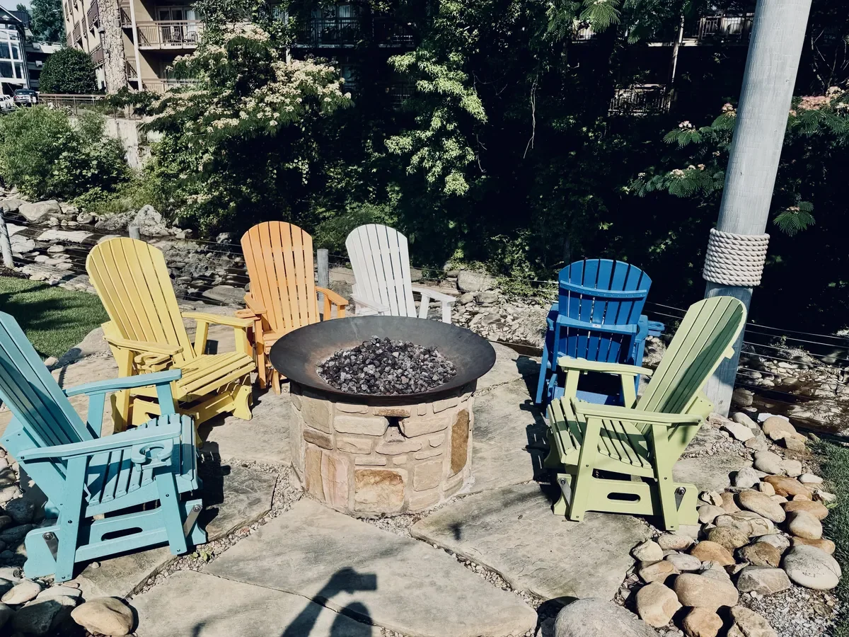fire pit with colorful chairs around it