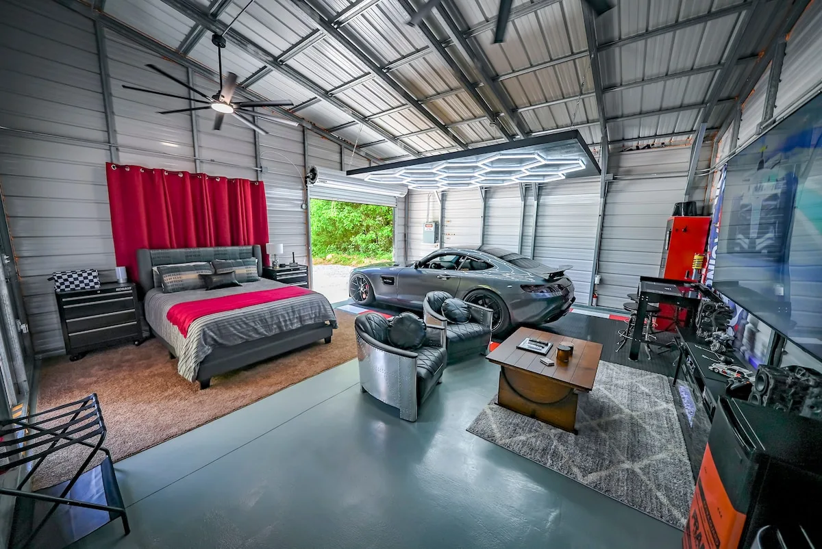 A sports car parked inside BlackTop Lodge Studio right next to the bed