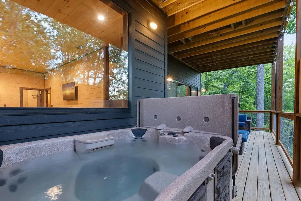 Hot tub on cabin deck surrounded by trees