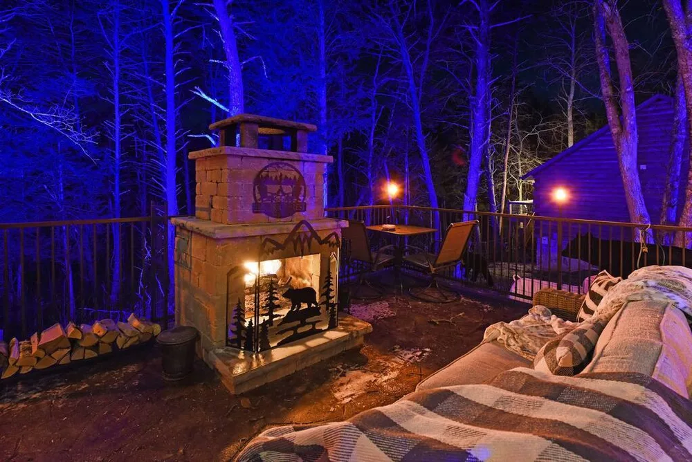 Outdoor fireplace on cabin deck at night