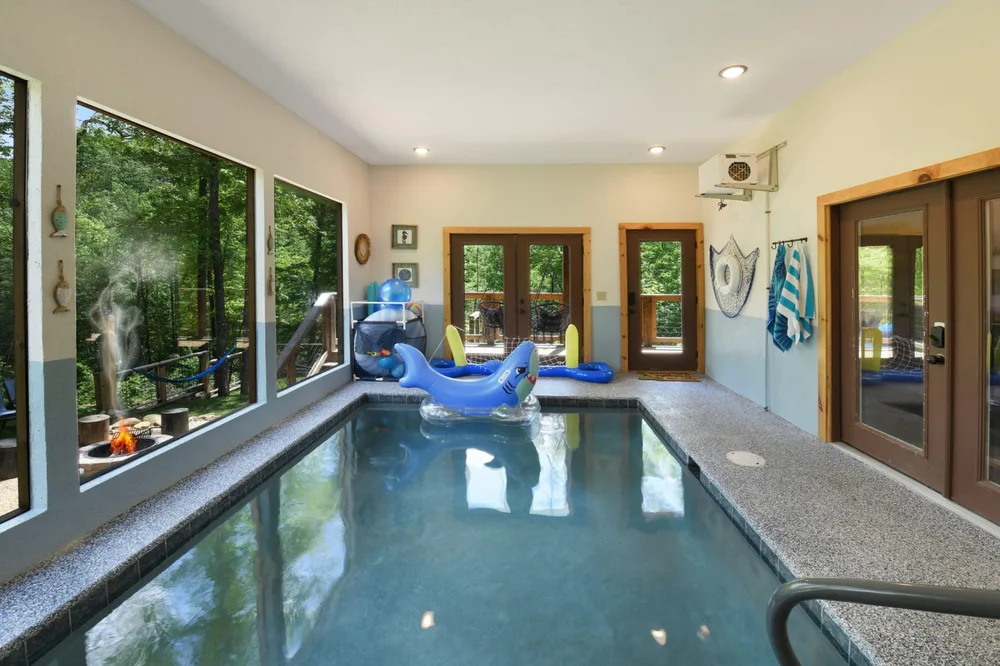 Indoor pool with large windows overlooking trees