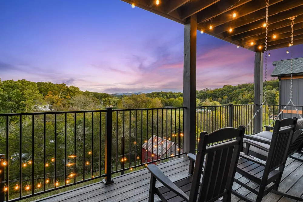 Deck overlooking trees and sunset sky