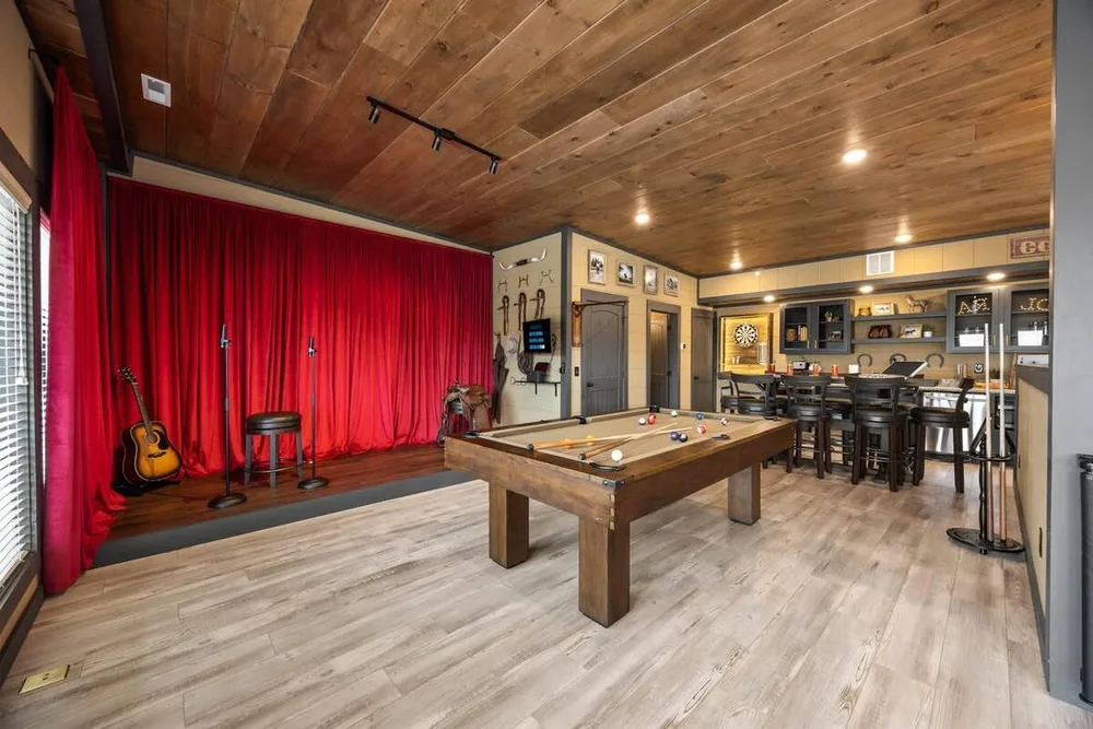 Game room with pool table and stage