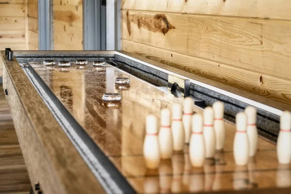 Shuffleboard table with bowling pins setup